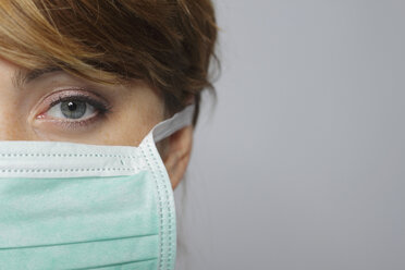 Female doctor wearing surgical mask, portrait, close-up - MBEF00022