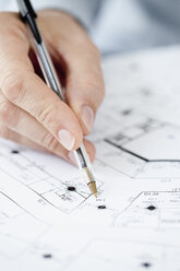 Architect pointing at blueprint with pen, close-up of hand - JRF00162