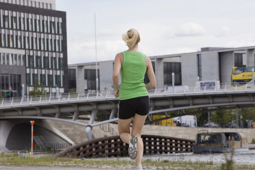 Deutschland, Berlin, Junge Frau beim Joggen, Rückansicht - SKF00123