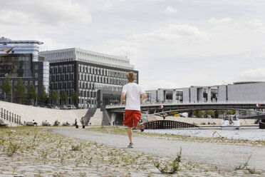 Deutschland, Berlin, Junger Mann beim Joggen, Rückansicht - SKF00122