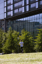 Deutschland, Berlin, Junger Mann beim Joggen, Rückansicht - SKF00079