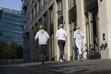 Deutschland, Berlin, Drei Freunde joggen zusammen - SKF00071