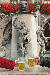 Deutschland, Bayern, München, Hände halten Bierkrüge am Springbrunnen, Nahaufnahme - WESTF14018