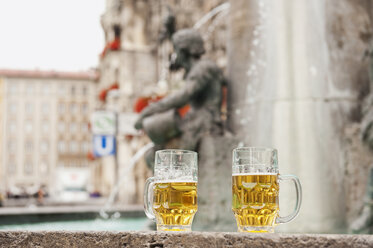 Deutschland, Bayern, München, Marienplatz, Zwei Bierkrüge stehen am Brunnen - WESTF14017