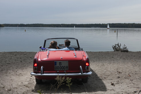 Deutschland, Berlin, Wannsee, Junges Paar im Cabrio mit Blick auf den See, Rückansicht - WESTF13985