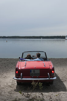 Deutschland, Berlin, Wannsee, Junges Paar im Cabrio mit Blick auf den See, Rückansicht - WESTF13984