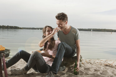 Germany, Berlin, Lake Wannsee, Young couple having a barbecue - WESTF13974