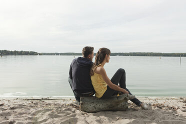 Germany, Berlin, Lake Wannsee, Young couple relaxing on beach, rear view - WESTF13962