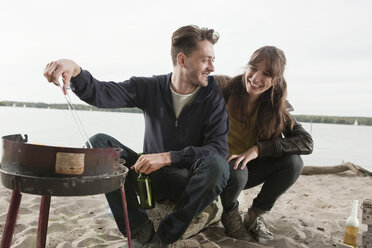 Germany, Berlin, Lake Wannsee, Young couple having a barbecue - WESTF13958