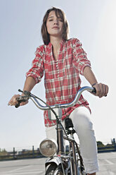 Deutschland, Berlin, Junge Frau mit Fahrrad auf Parkdeck stehend, Portrait - WESTF13932