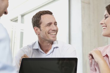 Germany, Cologne, Three business people in office using laptop - JOF00091