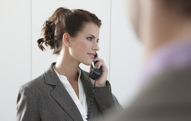 Germany, Cologne, Businesswoman using phone, looking away - JOF00036