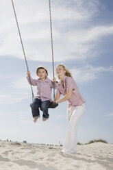 Germany, Schleswig Holstein, Amrum, Mother playing with son (3-4) on swing - RBF00164