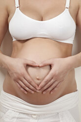 Pregnant woman holding belly, close-up - MAEF02012