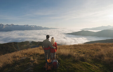 Österreich, Steiermark, Reiteralm, Wanderpärchen bewundert Aussicht über Wolken, Rückansicht - HHF03136