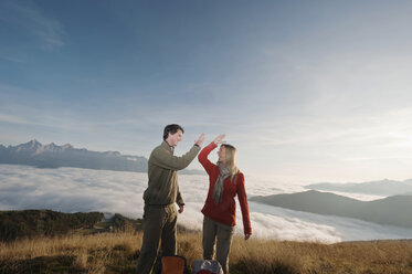 Österreich, Steiermark, Reiteralm, Wandererpaar tauscht High-Fives aus, lachend, Porträt - HHF03135