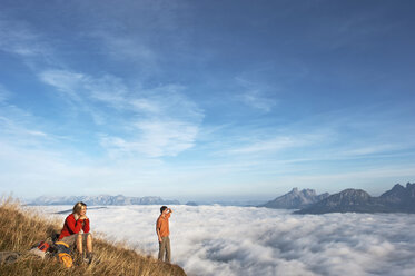 Österreich, Steiermark, Reiteralm, Wanderer bewundern Aussicht über Wolken - HHF03122