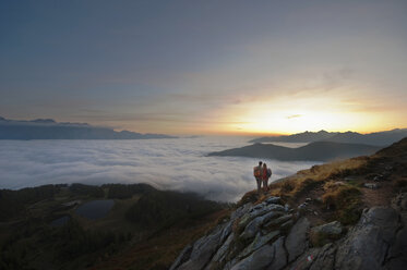 Austria, Steiermark, Reiteralm, Hikers admiring view over clouds - HHF03118