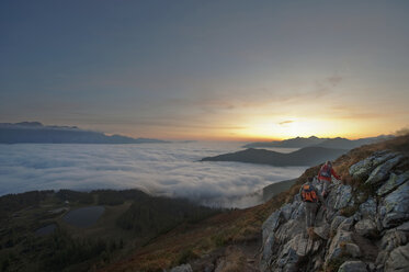 Österreich, Steiermark, Reiteralm, Wanderer bewundern Aussicht über Wolken - HHF03117