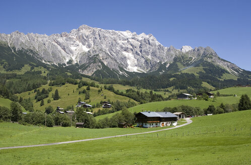 Österreich, Land Salzburg, Haus in Landschaft mit Bergkette im Hintergrund - WWF01180