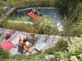 Österreich, Salzburger Land, Jugendliche (14-15) entspannen sich am Pool im Garten, Blick von oben - WWF01122