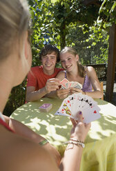 Österreich, Salzburger Land, Jugendliche (14-15) spielen Karten im Garten - WWF01119