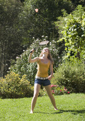 Austria, Salzburger Land, Teenage girl (14-15) playing badminton in garden, looking up - WWF01100