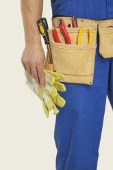 Man wearing tool belt and holding hammer, mid section, close-up - WESTF14502