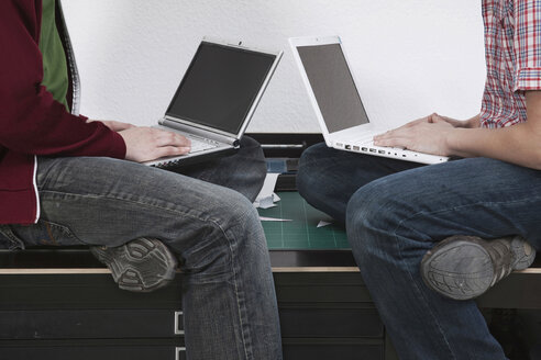 Männer sitzen am Schreibtisch und benutzen einen Laptop. - WESTF14448