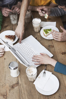 Freunde benutzen einen Laptop, frühstücken. - WESTF14393