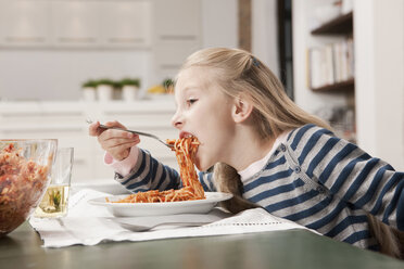 Germany, Cologne, Girl (6-7) eating spaghetti, side view, portrait - WESTF14363