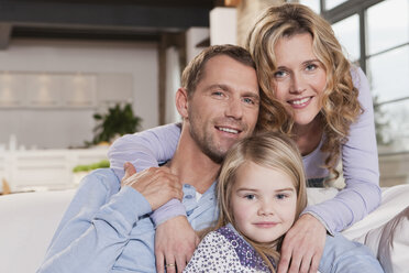 Germany, Cologne, Family sitting on sofa, smiling, portrait, close-up - WESTF14255