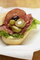 Sandwich mit Salami, Oliven und Salat auf einem Teller, Nahaufnahme - SCF00403