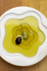 Olive oil with olives in bowl, elevated view - SCF00370