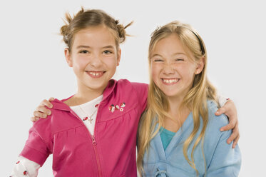 Zwei Mädchen (8-9) umarmen sich, lächelnd, Porträt - RNF00231