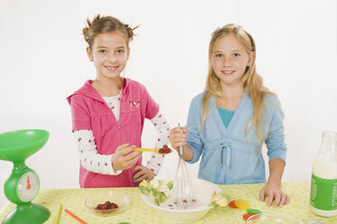 Zwei Mädchen in der Küche bei der Zubereitung einer Mahlzeit, Porträt - RNF00228