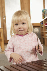 Germany, Portrait of a girl (3-4) playing xylophone, close-up - RNF00213