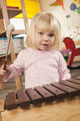 Germany, Portrait of a girl (3-4) playing xylophone, close-up - RNF00210