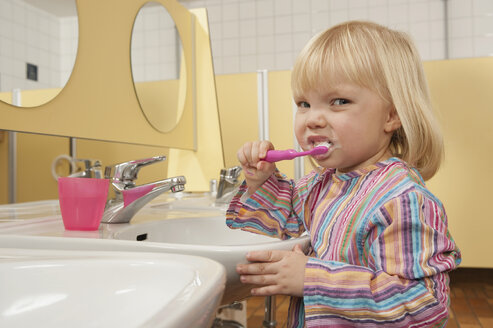 Germany, Girl (3-4) in lavatory brushing her teeth, side view, portrait, close-up - RNF00200