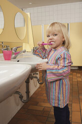 Germany, Girl (3-4) in lavatory brushing her teeth, side view, portrait - RNF00199