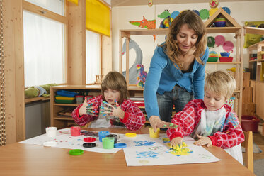 Deutschland, Zwei Jungen (3-4), (6-7) malen mit den Fingern im Kinderzimmer - RNF00178