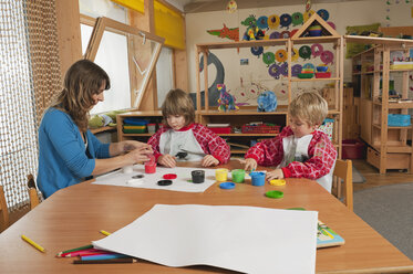 Deutschland, Zwei Jungen (3-4), (6-7) malen mit den Fingern im Kinderzimmer - RNF00173