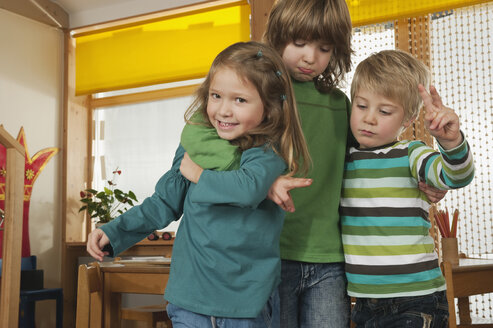 Deutschland, Kinder im Kinderzimmer spielen zusammen, lächelnd, Porträt - RNF00172