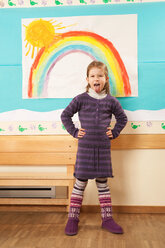 Deutschland, Porträt eines Mädchens (4-5) im Kinderzimmer, Hände auf den Hüften - RNF00140