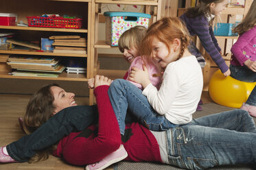 Germany, Nursery, Female nursery teacher and children playing together - RNF00132