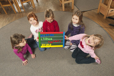 Deutschland, Kinder im Kinderzimmer halten Briefkasten, Ansicht von oben - RNF00114
