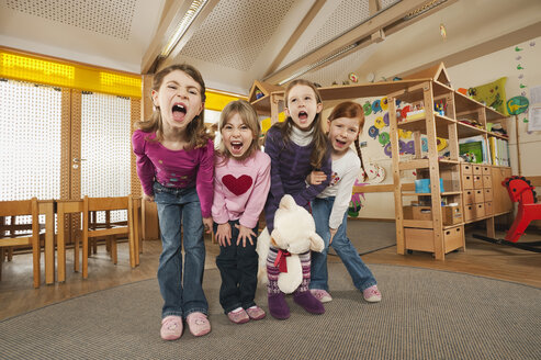 Deutschland, Kinder im Kinderzimmer stehend nebeneinander schreiend, Porträt - RNF00107