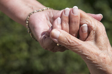 Senior women holding hands, close-up - NHF01190