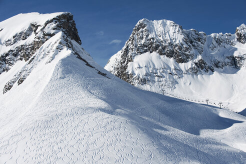 Österreich, Arlberg, Bergkulisse, Skispuren auf der Piste - MIRF00026