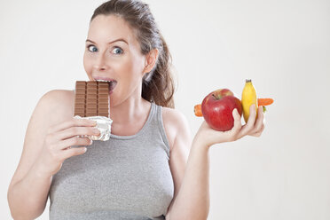 Schwangere Frau isst eine Tafel Schokolade, Porträt - MAEF02062